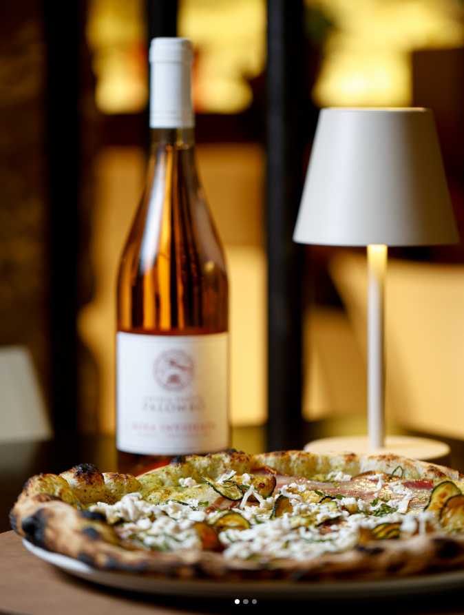 Pizza gourmet con bottiglia di vino rosato